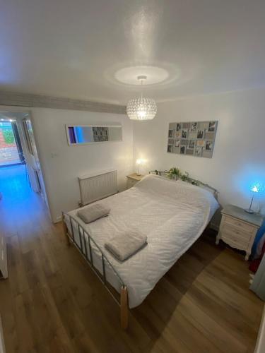 Un dormitorio con una cama grande y una lámpara de araña. en Chapel Court - Worcester City Centre - Free Parking Available - Entire Apartment - Self Check-In - Outside Space - Free WI-FI en Worcester