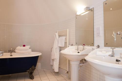 a bathroom with two sinks and a bathtub and a tub and sink at Royal Golf Hotel in Dornoch