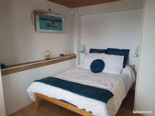 une chambre avec un lit avec un oreiller bleu dessus dans l'établissement Chalet Le Casalandre, à Arette