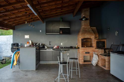 een keuken met een bakstenen oven en een tafel en stoelen bij Recanto Sol Poente in Caçapava
