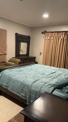 1 dormitorio con 1 cama grande y espejo en فيلا العزيزيه - الخبر, en Mīnāʼ al ‘Azīzīyah