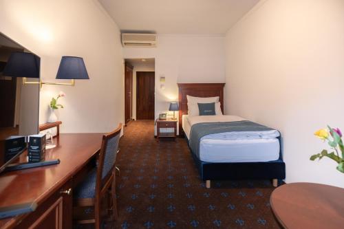 ウィーンにあるSelect Hotel Prinz Eugen Wienのベッドとデスクが備わるホテルルームです。