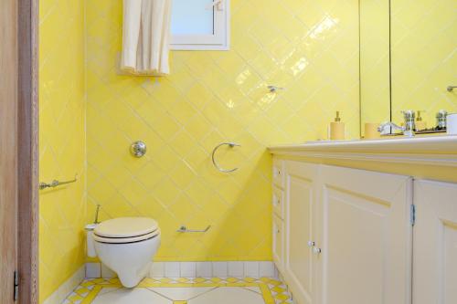 a yellow bathroom with a toilet and a sink at Terrazza sul mare a Porto Cervo in Porto Cervo