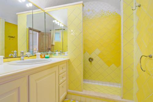 a yellow bathroom with a sink and a shower at Terrazza sul mare a Porto Cervo in Porto Cervo