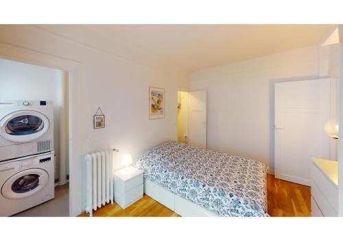a bedroom with a bed and a washing machine at Comfy 1-bed Retreat Near Champ de Mars in Paris