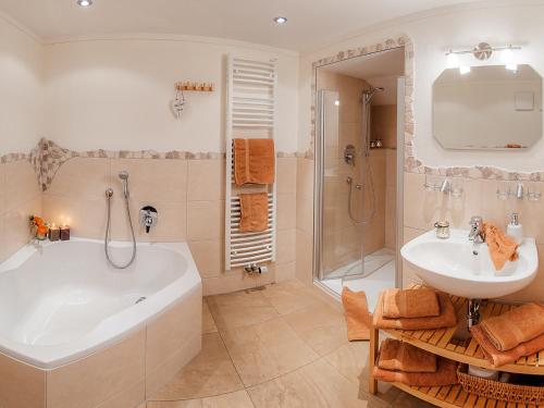 La salle de bains est pourvue d'une baignoire, d'un lavabo et d'une douche. dans l'établissement Sotterhof - Chiemgau Karte, à Inzell