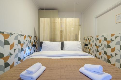 雅典Fully Renovated Flat in Prime Athens Location的一间卧室配有一张床,上面有两条毛巾