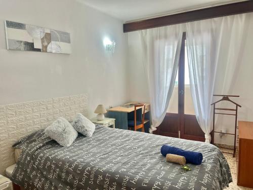 Un dormitorio con una cama con una almohada azul. en Habitacion LUMINOSA en Palma para una sola persona en casa familiar, en Palma de Mallorca