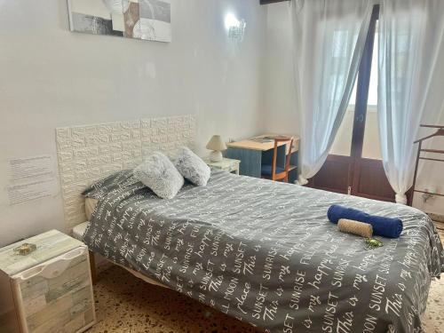 a bedroom with a bed with a blue and white comforter at Habitacion LUMINOSA en Palma para una sola persona en casa familiar in Palma de Mallorca