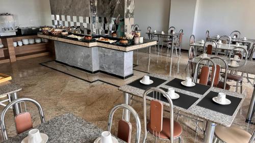 a restaurant with tables and chairs and a counter with food at NORTH HOTEIS in Montes Claros