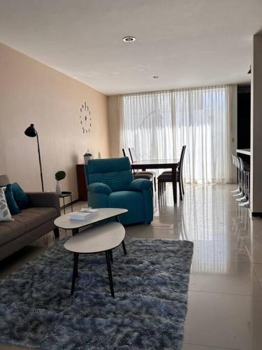 a living room with a blue couch and a table at Nueva Galicia residencial, es una propiedad completa al sur de la ciudad que te ofrece modernidad, espacio, tranquilidad, cuenta con 4 recamaras 3 baños completos y 2 cajones de estacionamiento privados in Guadalajara