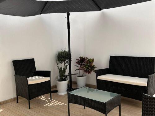 a patio with two chairs and a table and an umbrella at Casa Bon ya está lista, propiedad completa en Nueva Galicia Residencial Zona sur de la Ciudad de Guadalajara, jalisco México in Guadalajara