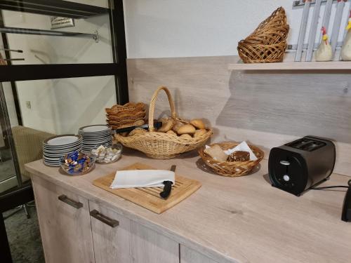 a counter with baskets of food and a toaster at Hotel Stadt Witzenhausen in Witzenhausen