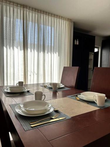 a table with plates and utensils on top of it at Nueva Galicia residencial, es una propiedad completa al sur de la ciudad que te ofrece modernidad, espacio, tranquilidad, cuenta con 4 recamaras 3 baños completos y 2 cajones de estacionamiento privados in Guadalajara