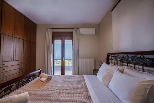 a bedroom with a bed with a view of the ocean at Villa Aris: A Serene Experience, 3BRs, Pool & Bbq in Magnisía