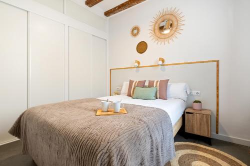 a bedroom with a large bed with a tray on it at Lodging Apartments Almirall Beach 51 in Barcelona