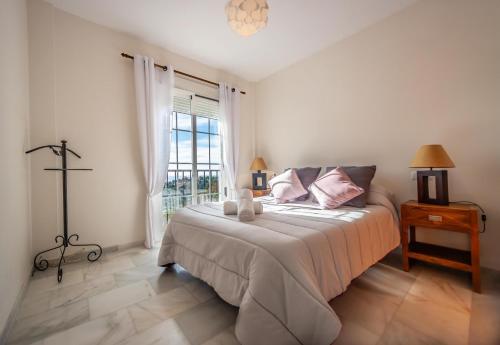 ein weißes Schlafzimmer mit einem Bett und einem Fenster in der Unterkunft Villa Puerto Blanquillo in Frigiliana