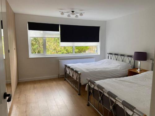 a bedroom with two beds and a window at Spacious - 3 double beds - Wi-Fi - Central Northwood - Free Parking in Northwood
