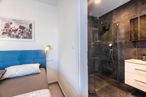 a bathroom with a shower and a bed in a room at Villa Gräfin in Malinska