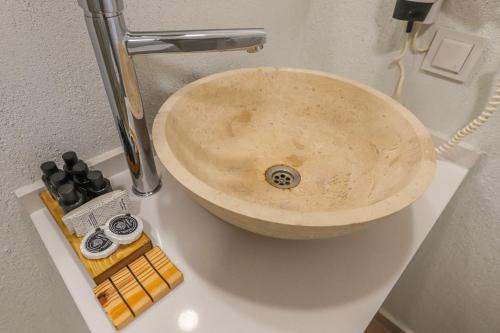 a stone sink in a bathroom with someiazepines andiazeputes at Mavi Cam Hotel Ayvalik in Sefaçamlık
