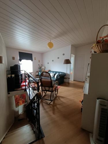 a living room with a couch and a table at Maison De Village in Barbechat