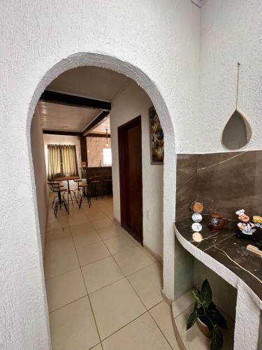 corridoio con arco in cucina con tavolo di Residência Saquarema a Saquarema