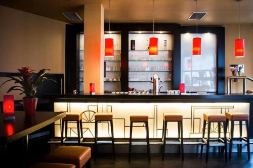 bar w restauracji z stołkami barowymi w obiekcie Ramada by Wyndham Bottrop City w mieście Bottrop