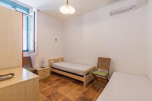 um quarto com uma cama e uma cadeira em Casa del Glicine em Marina di Ragusa
