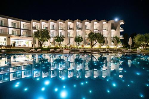 a pool in front of a hotel at night at Amaronda Resort & Spa Eretria in Eretria