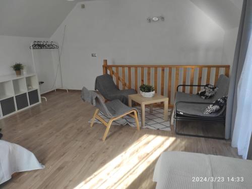 sala de estar con 2 sillas y mesa en Domek w górach, en Sucha Beskidzka