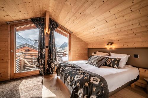 une chambre avec un lit et une grande fenêtre dans l'établissement Chalet Inari Chamonix - by EMERALD STAY, à Chamonix-Mont-Blanc
