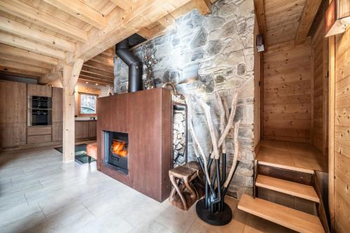une cheminée dans une pièce avec un mur en pierre dans l'établissement Chalet Inari Chamonix - by EMERALD STAY, à Chamonix-Mont-Blanc