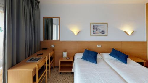 a hotel room with two beds and a desk at Hotel Samba in Lloret de Mar