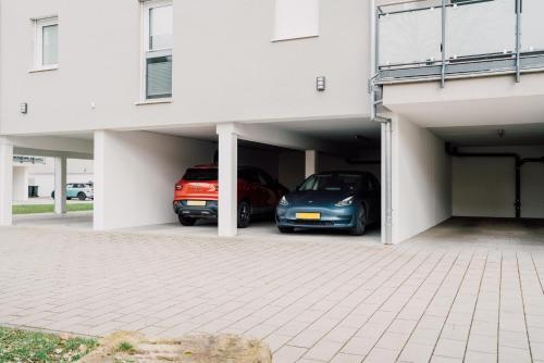 two cars are parked in a garage at Modern Apartm. Wanderlust with Home Cinema in Echternacherbrück