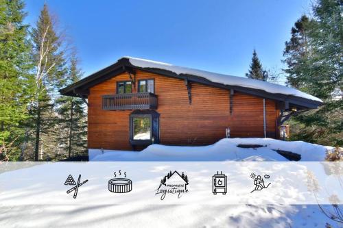 una cabaña de madera con nieve delante en Chalet Suisse, SPA, Billard, Ski et Montagne, en Sainte-Agathe-des-Monts