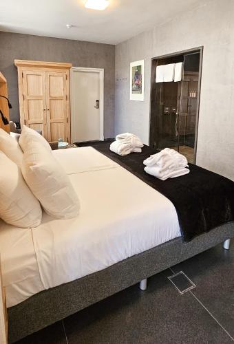two beds in a hotel room with towels on them at Villa Valkenburg in Valkenburg