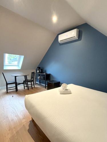 1 dormitorio con 1 cama y aire acondicionado en la pared en Onyx Blue, en Saint-Aignan