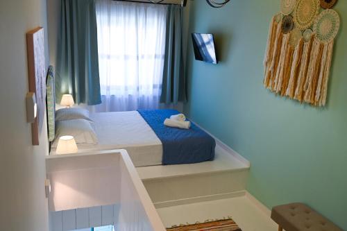 a small bedroom with a bed with a blue blanket at Koskinou Traditional Houses in Koskinou