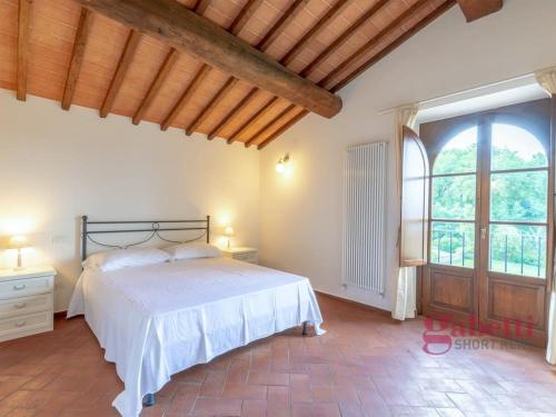 ein Schlafzimmer mit einem Bett und einem großen Fenster in der Unterkunft Il Ciliegio - I Borghi Della Selvaccia in Cennina