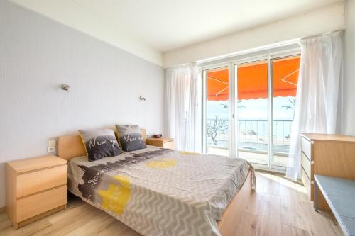 a bedroom with a bed and a large window at Angelina - La002 in Cagnes-sur-Mer