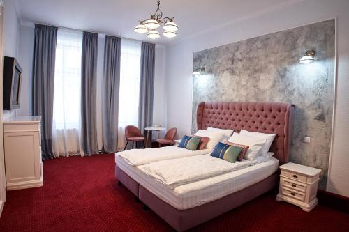 a bedroom with a large bed and a red carpet at Charma Residence in Sibiu