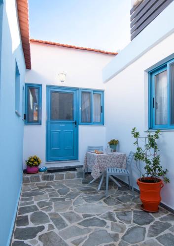 a blue door on a white house with a table at Koskinou Traditional Houses in Koskinou