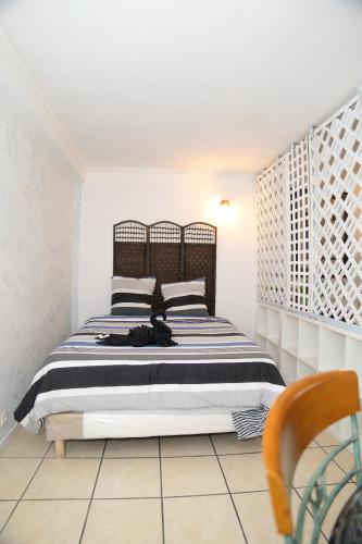 une chambre avec un lit avec une couverture noire et blanche dans l'établissement Agréable maison en centre ville, à Noisy-le-Grand
