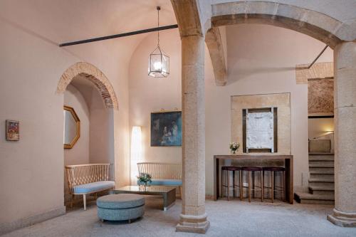 a living room with two columns and a fireplace at NH Collection Cáceres Palacio de Oquendo in Cáceres