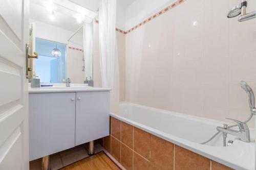une salle de bain avec une baignoire blanche et un lavabo dans l'établissement Le St Charles, Charmant T2, Terrasse, Centre ville, à Montpellier