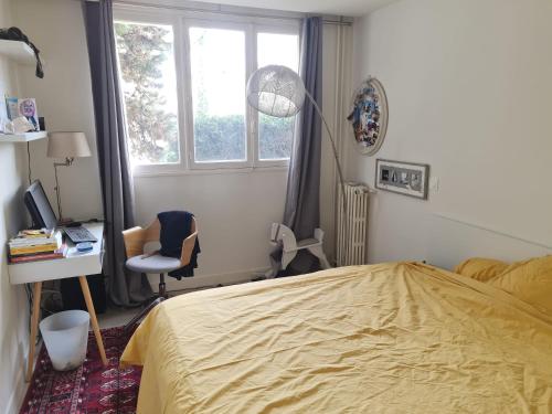 une chambre avec un lit, un bureau et une fenêtre dans l'établissement Appartement spacieux près de Chatou avec jardin clôturé, à Chatou