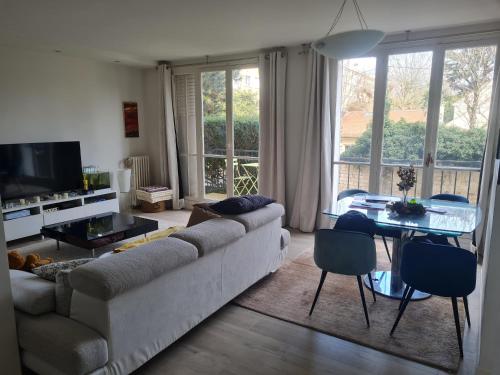 un salon avec un canapé et une table dans l'établissement Appartement spacieux près de Chatou avec jardin clôturé, à Chatou