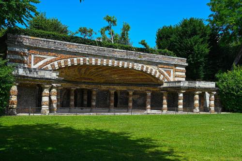 une grande structure en pierre avec un champ herbeux dans l'établissement Appartement spacieux près de Chatou avec jardin clôturé, à Chatou