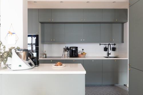 eine Küche mit grauen Schränken und einer weißen Arbeitsplatte in der Unterkunft Beautiful family home in Boulogne-Billancourt in Boulogne-Billancourt
