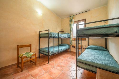 a room with three bunk beds and a table at Brezza di Mare in Calasetta